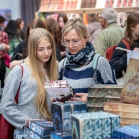 Zwei Frauen lesen in einem Buch auf der Leipziger Buchmesse 2025 Zwei Frauen lesen in einem Buch auf der Leipziger Buchmesse 2025