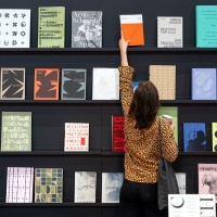 Besucherin der Leipziger Buchmesse 2025 nimmt ein Buch aus einer Wand mit ausgestellten Büchern Besucherin der Leipziger Buchmesse 2025 nimmt ein Buch aus einer Wand mit ausgestellten Büchern