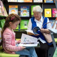 Altere Frau liest mit Enkelin Bücher auf der Leipziger Buchmesse 2019 Altere Frau liest mit Enkelin Bücher auf der Leipziger Buchmesse 2019