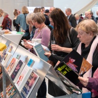 Lesende Besucher:innen am Messestand des Gastlands auf der Leipziger Buchmesse 2024 Lesende Besucher:innen am Messestand des Gastlands auf der Leipziger Buchmesse 2024