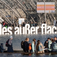 Außenansicht von Glashalle und Messesee mit Fokus auf den Slogan "alles außer flach" während der Leipziger Buchmesse 2024 Außenansicht von Glashalle und Messesee mit Fokus auf den Slogan "alles außer flach" während der Leipziger Buchmesse 2024