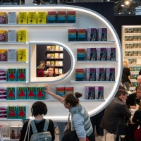 Impression von der Ausstellungsfläche der Leipziger Buchmesse 2024 mit Messeständen und Besucher:innen