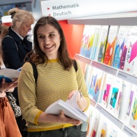 Lesende Besucherin an einem Messestand mit großem Bücherregal auf der Leipziger Buchmesse 2024 Lesende Besucherin an einem Messestand mit großem Bücherregal auf der Leipziger Buchmesse 2024