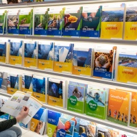 Lesender Besucher an einem Messestand mit großem Bücherregal auf der Leipziger Buchmesse 2024 Lesender Besucher an einem Messestand mit großem Bücherregal auf der Leipziger Buchmesse 2024