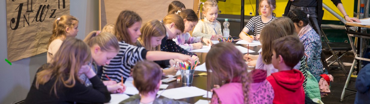 Kinder malen an einem großen Tisch im UVERSE auf der Leipziger Buchmesse 2024 Kinder malen an einem großen Tisch im UVERSE auf der Leipziger Buchmesse 2024