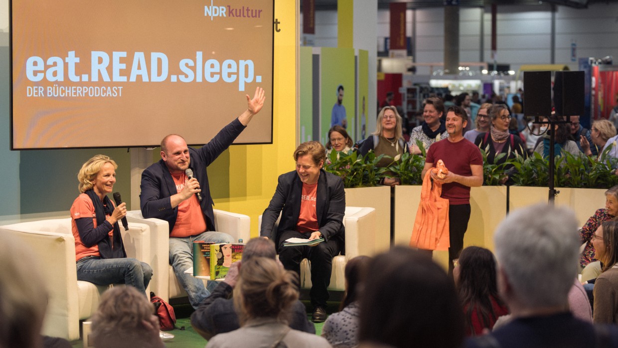 Bühnenveranstaltung des Podcasts "eat.read.sleep." mit mehreren Personen in der Audiowelt der Leipziger Buchmesse 2025 vor vollbesetztem Publikum