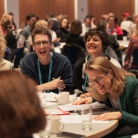 fröhliche Tischgespräche im vollen Saal der Leipziger Autor:innenrunde 2025