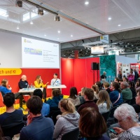 4 Personen sitzen bei einer Diskussionsrunde auf der Bühne vor Publikum im Forum Mensch & KI auf der Leipziger Buchmesse 2025