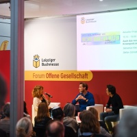 3 Personen sitzen bei einer Diskussionsrunde auf der Bühne vor Publikum im Forum Offene Gesellschaft auf der Leipziger Buchmesse 2025 3 Personen sitzen bei einer Diskussionsrunde auf der Bühne vor Publikum im Forum Offene Gesellschaft auf der Leipziger Buchmesse 2025