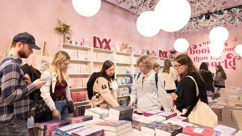 Besucher:innen stöbern durch die Bücher am LYX Stand 