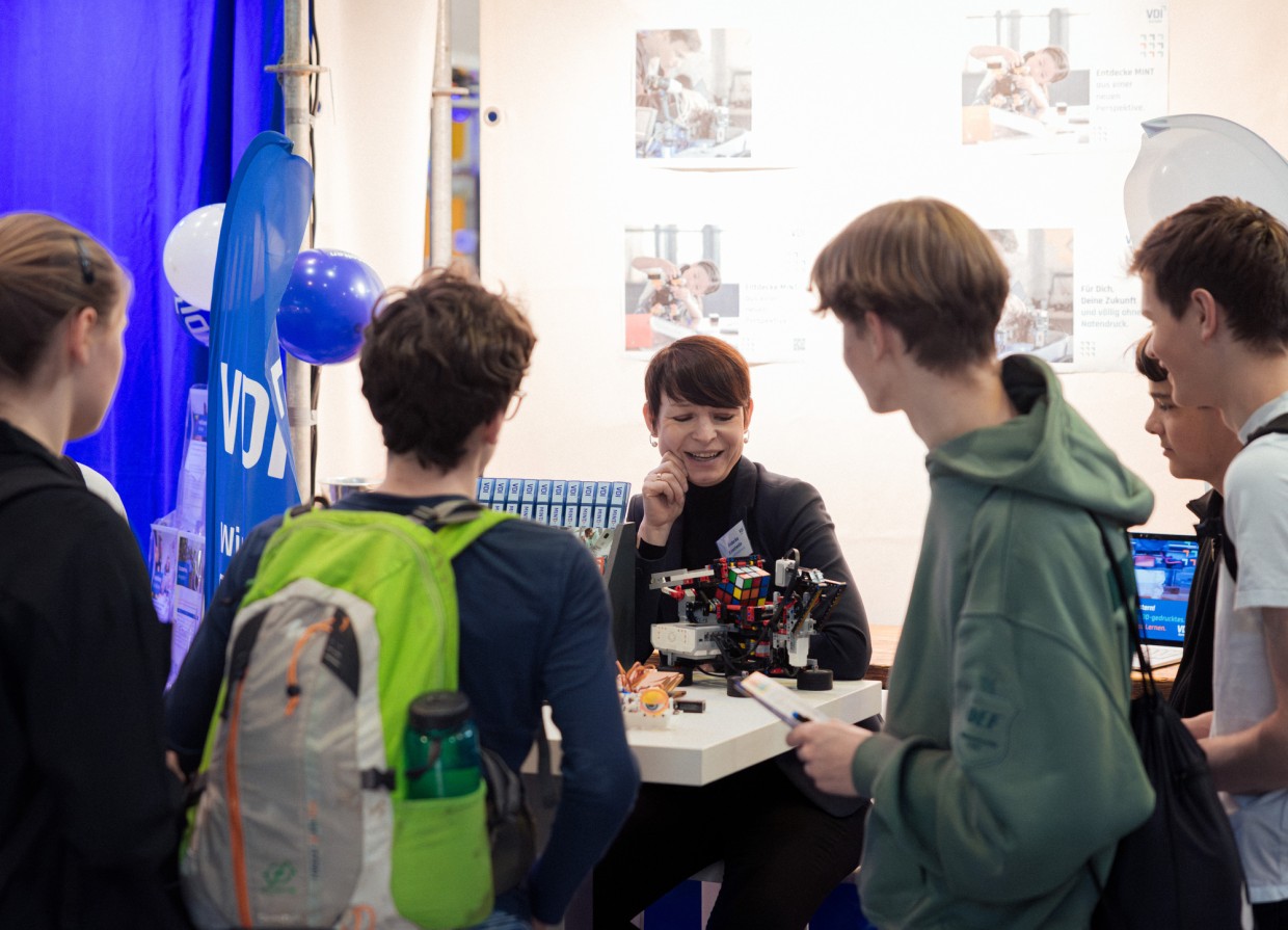 VDI Messestand mit Ausstellerin und mehreren jungen Besucher:innen auf der Leipziger Buchmesse 2025