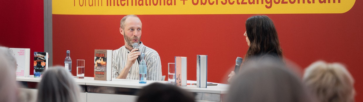 Bühnengespräch mit 2 Teilnehmer:innen auf der Bühne des Forum International + Übersetzungszentrum auf der Leipziger Buchmesse 2025