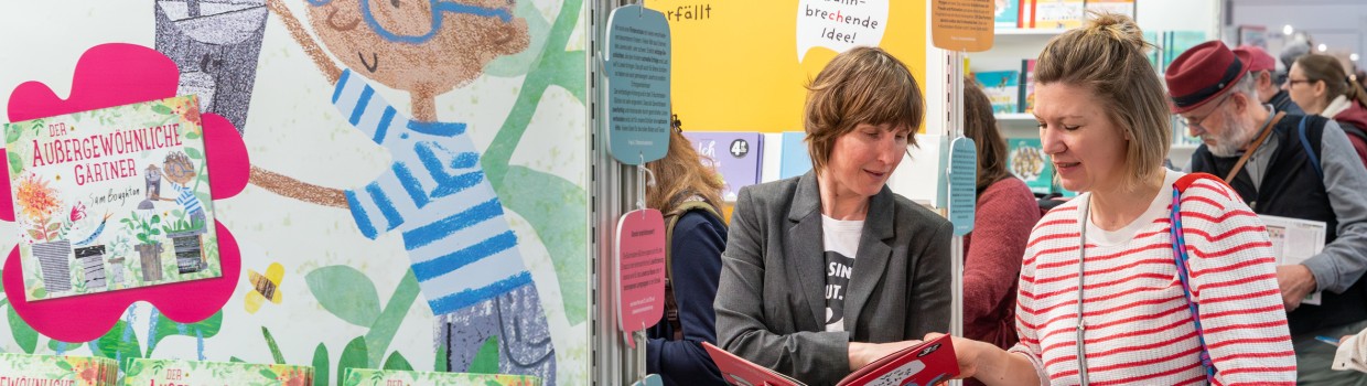 Zwei Frauen unterhalten sich über ein Kinderbuch auf der Leipziger Buchmesse 2025 Zwei Frauen unterhalten sich über ein Kinderbuch auf der Leipziger Buchmesse 2025