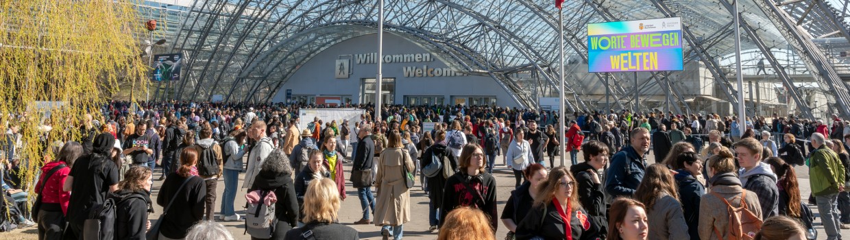 Impression von der Buchmesse 2025 mit vielen Besucher:innen vor dem Haupteingang der Glashalle