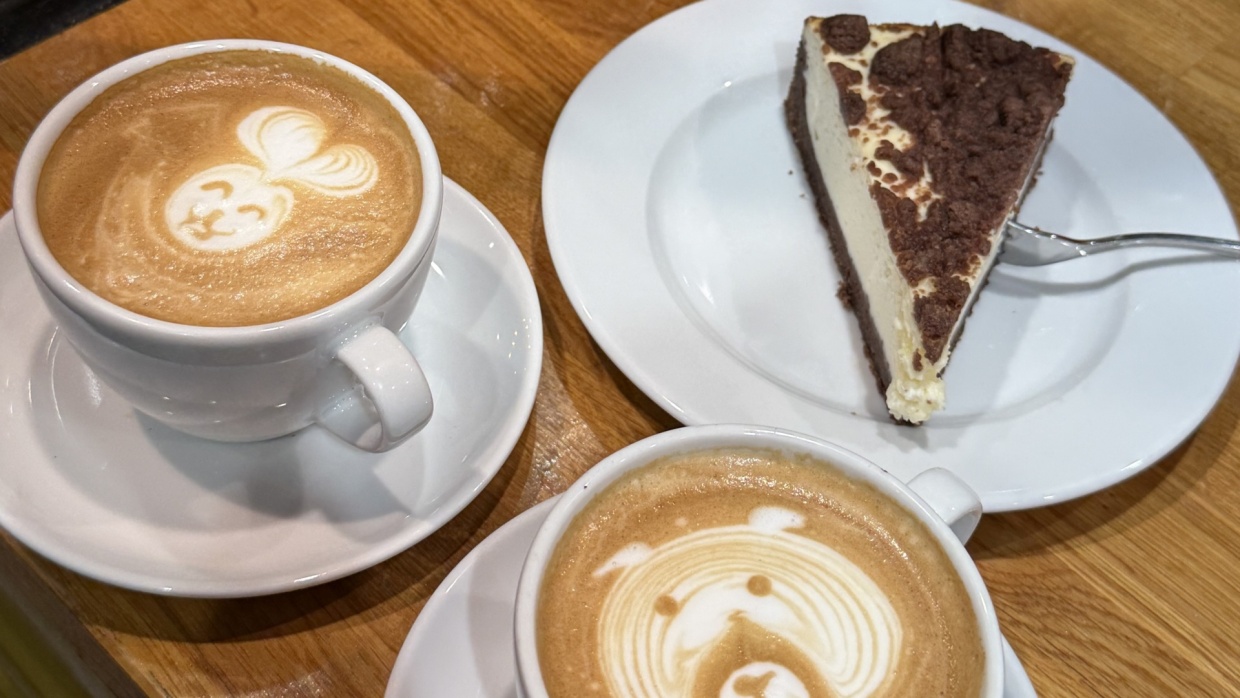 zwei Kaffeetassen, ein Stück Kuchen auf einem Tisch