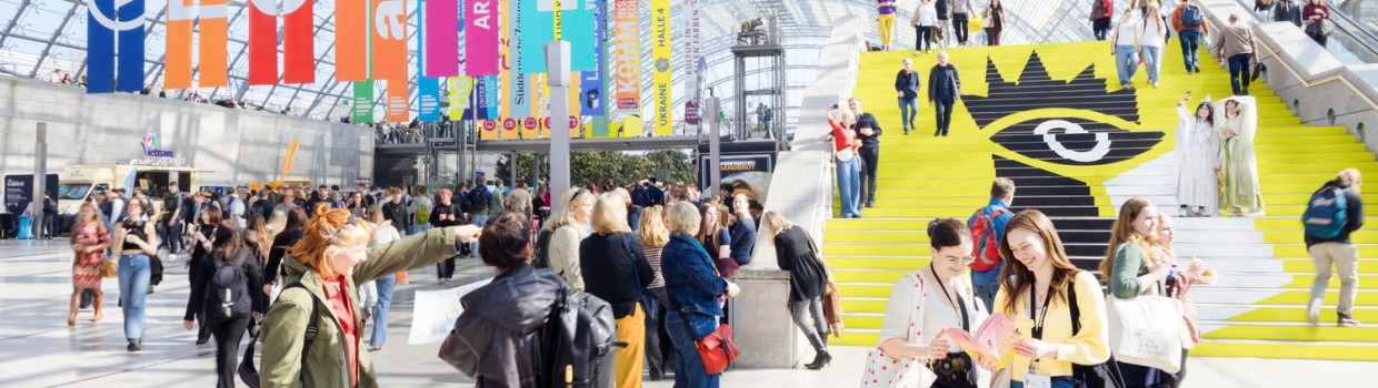 belebte Glashalle während der Leipziger Buchmesse mir fröhlichen Besucher:innen