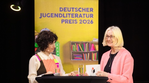 Zwei Damen präsentieren die Nominierten für den Deutschen Jugendliteraturpreis auf der Leipziger Buchmesse 2026