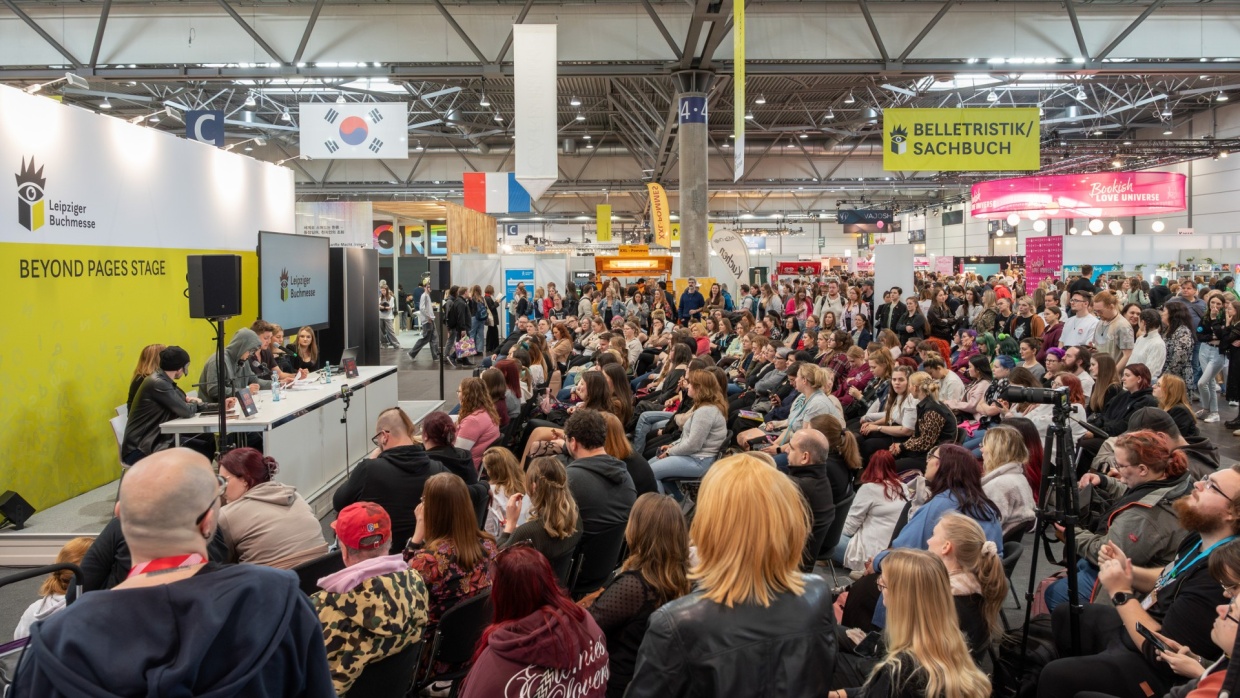 mehrere Personen im Gespräch auf der Bühne der Beyond Pages Stage vor vollbesetztem Publikum auf der Leipziger Buchmesse 2026