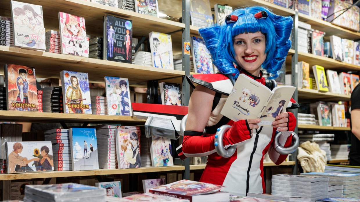 Macoco liest Manga an einem Messestand auf der Manga Comic Con 2026
