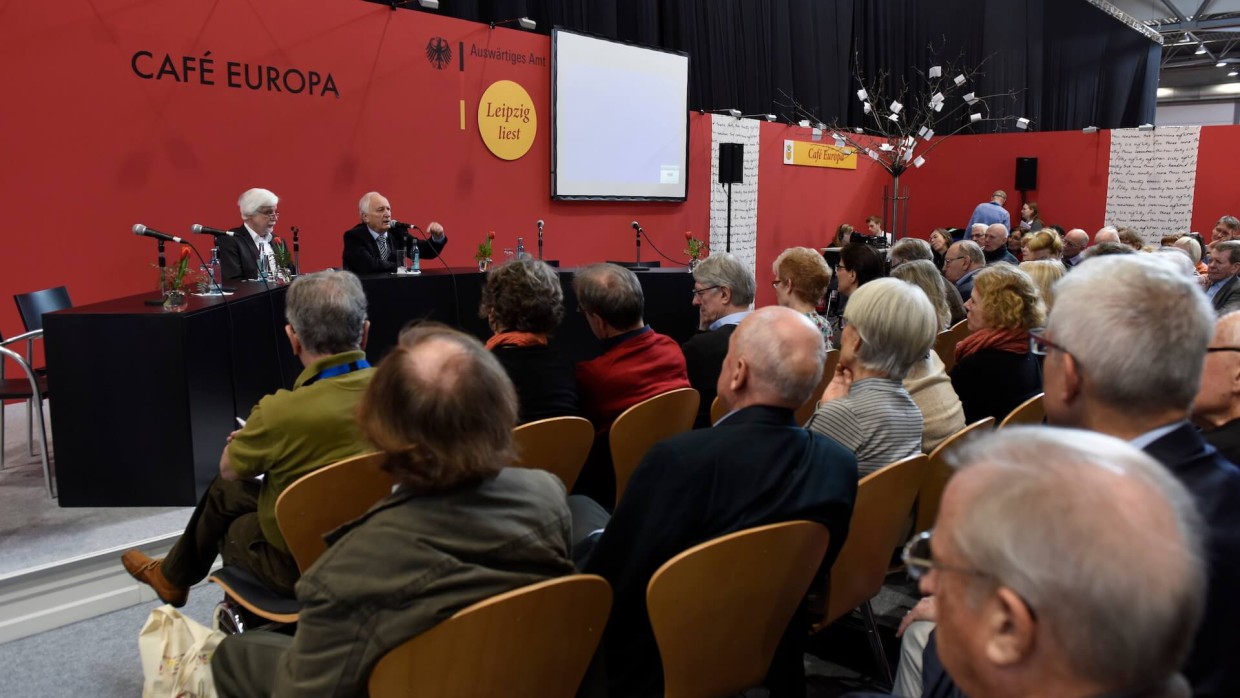 Eine Veranstaltung auf der Leipziger Buchmesse. Zwei Männer sitzen auf der Bühne an einem schwarzen Tisch, ihnen gegenüber das Publikum. Es handelt sich um das Café Europa. 