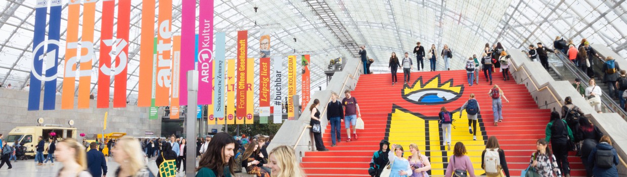 Impression of the interior of the glass hall at Leipzig Exhibition Center with red staircase at the 2025 Book Fair