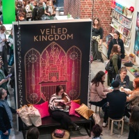 Impression of the Leipzig Book Fair 2025 with many visitors, some of whom are reading a book