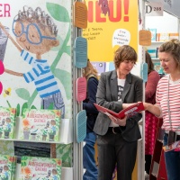 Two women talk about a children's book at the Leipzig Book Fair in 2025