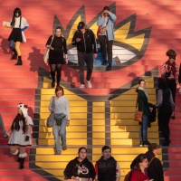 Visitors walk down stairs bearing the logo of the Leipzig Book Fair 2025