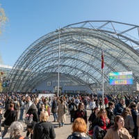Impression of the 2025 Book Fair with many visitors in front of the main entrance to the Glass Hall