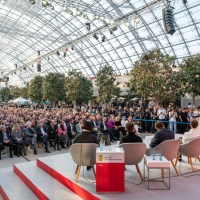 View from behind the stage of the award winners and presenters at the Leipzig Book Fair Prize 2025 ceremony, with the audience in the background.