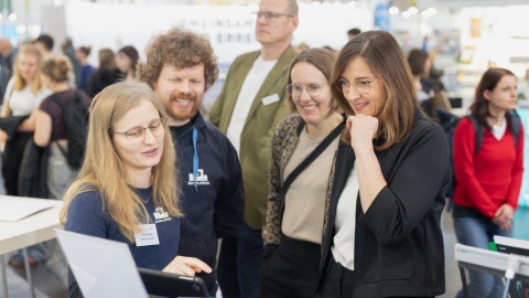 Exhibitors advise visitors at a booth counter during Leipzig Book Fair 2026