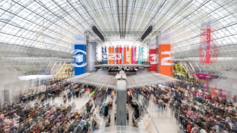 View of the crowded glass hall with colorful banners at Leipzig Book Fair 2026