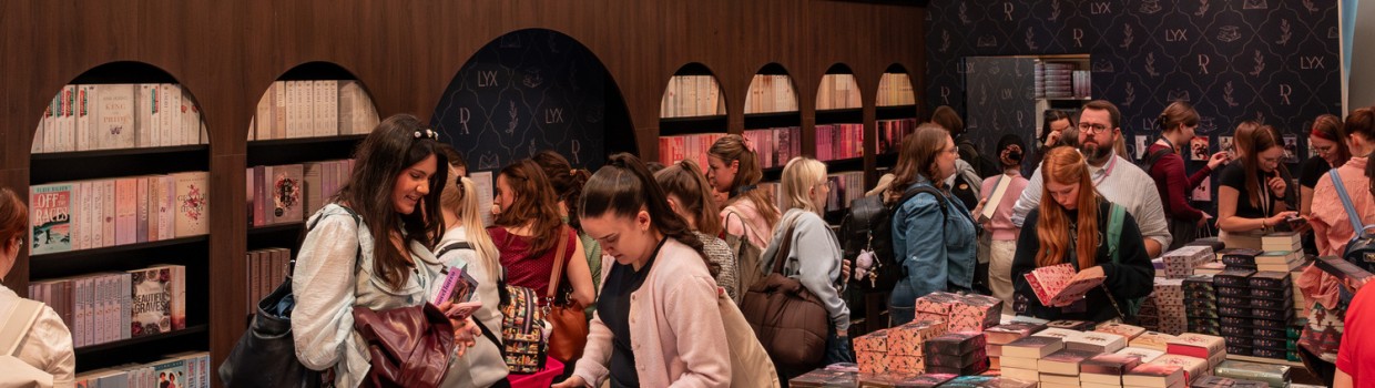 Visitors browse a decorated book stand beneath chandeliers at Leipzig Book Fair 2026