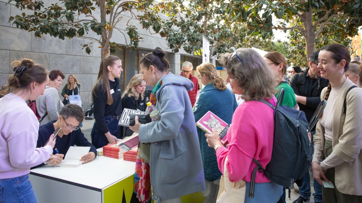 Author signs books for waiting visitors at Leipzig Book Fair 2026