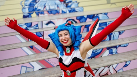 The mascot of Manga Comic Com 2025, Macoco, grins at the camera